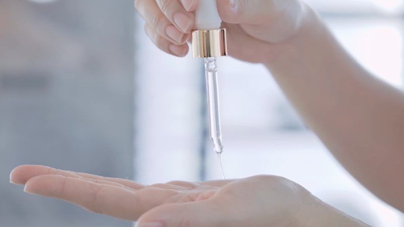 Žena sipa vitamin C serum na ruku